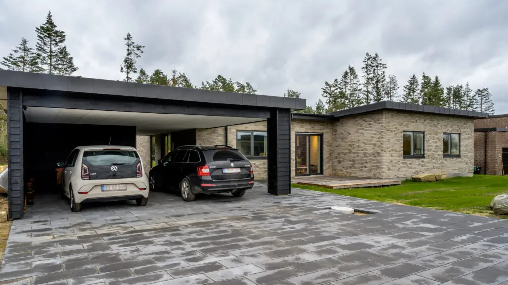 Moderne murstensvilla i Sejs med integreret carport og flisebelægning
