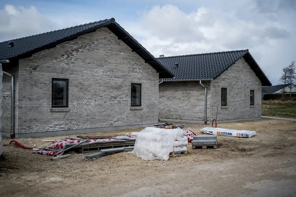 Opførelse og murerarbejde på boliger i grå mursten med byggematerialer på byggepladsen