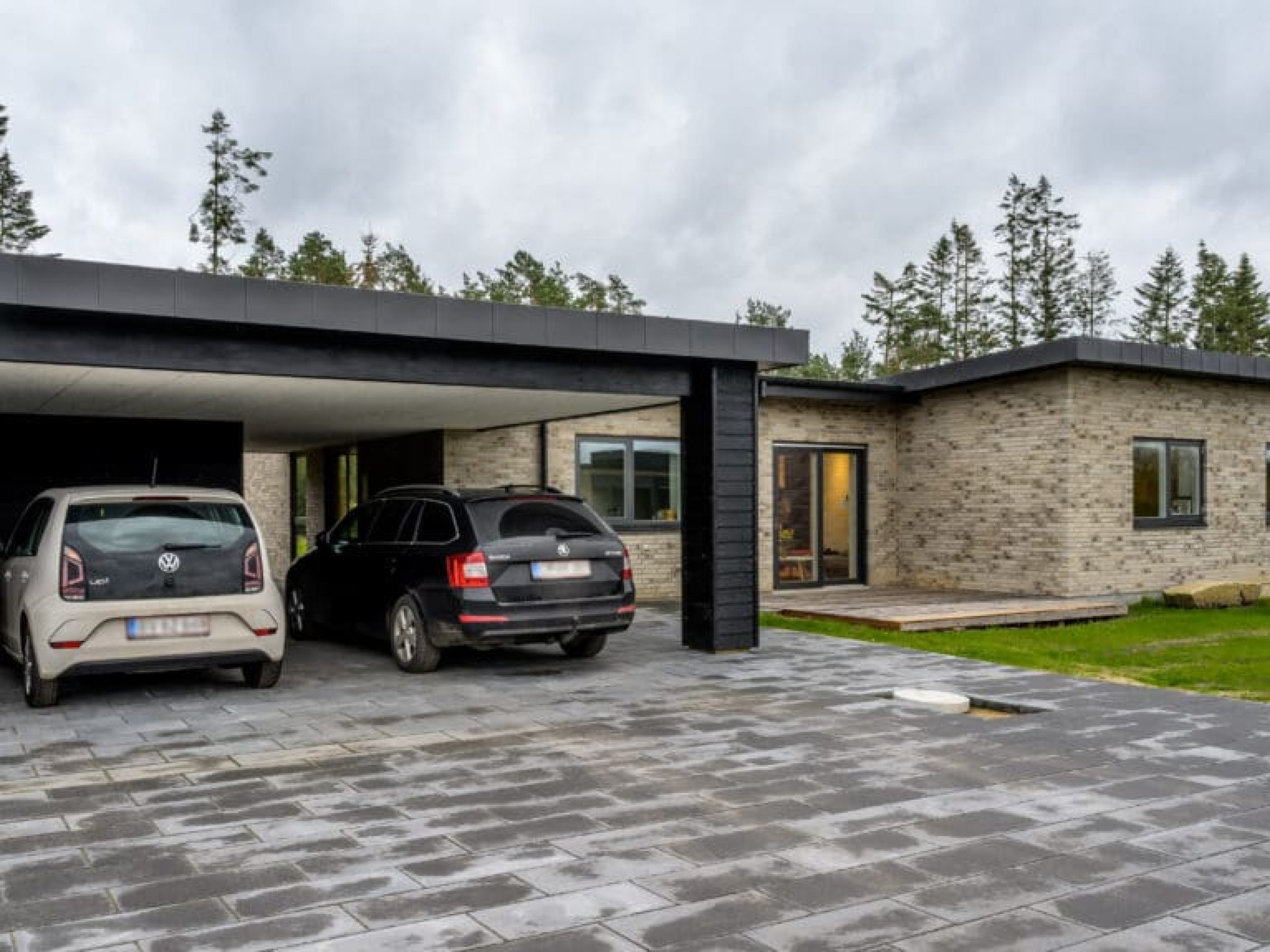 Moderne murstensvilla i Sejs med integreret carport og flisebelægning